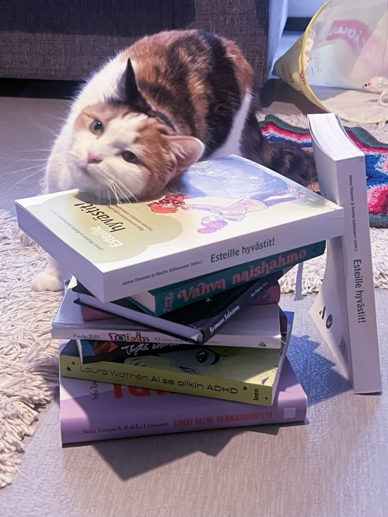 Kissa nojaa poskea Esteille hyvästit kirjan kanteen